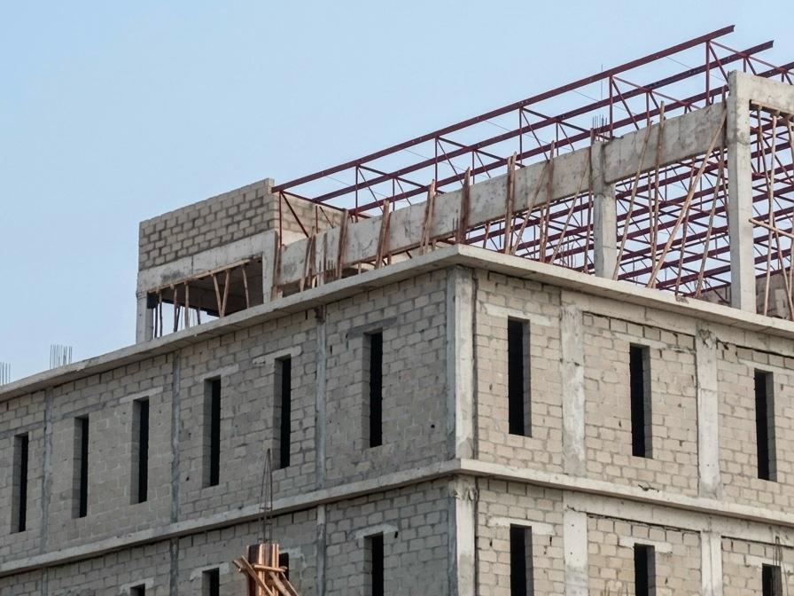 Steel frame of a roof under construction against blue sky